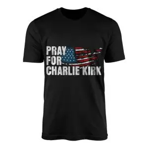 Black crew neck t-shirt featuring white block text Pray For Charlie Kirk beside a distressed American flag silhouette of the United States