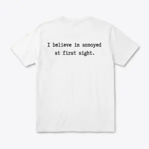 Back flat lay of a white t-shirt featuring black text reading I believe in annoyed at first sight.