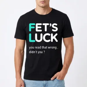 Fets Luck You Read That Wrong T-Shirt 8 Close-up of a t-shirt displaying the witty message 'FET’S LUCK you read that wrong, didn’t you?' on black fabric.