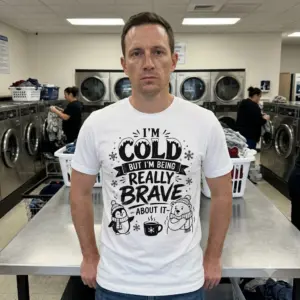 Funny 'I'm Cold But Brave' Winter T-Shirt 11 The humorous 'I'm Cold But I'm Being Really Brave About It' graphic on a white top, featuring a bundled-up penguin and shivering polar bear.