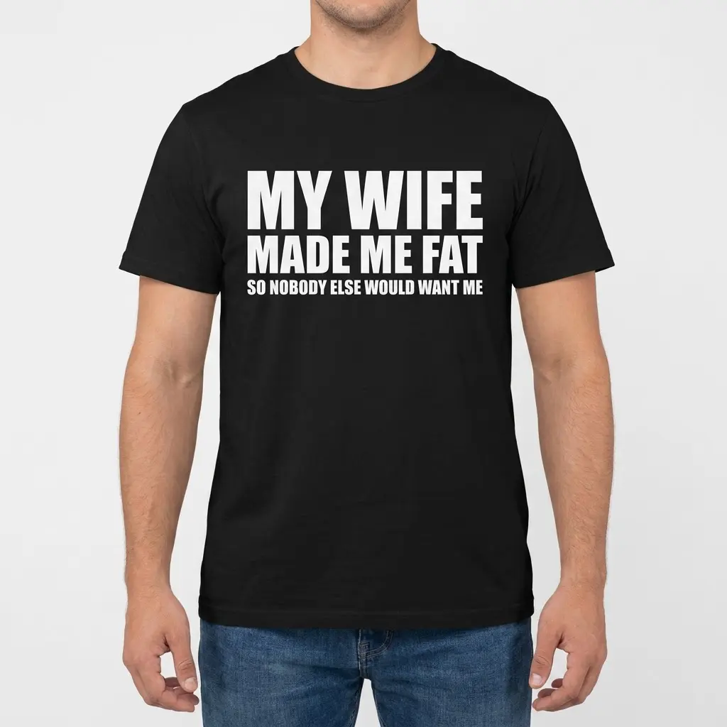 Front view of a man modeling a black t-shirt with the humorous quote My Wife Made Me Fat So Nobody Else Would Want Me.