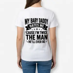 Funny Single Mom Baby Daddy Graphic T-Shirt 9 A woman shown from behind wearing a white graphic t-shirt that reads, My Baby Daddy Hates Me Cause I'm Twice The Man He'll Ever Be.