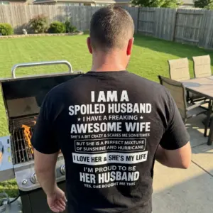 Funny Spoiled Husband Awesome Wife T-Shirt 10 Lifestyle setting showing the back of the black spoiled husband graphic shirt in everyday casual wear.