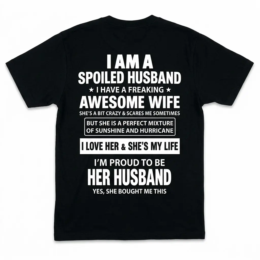 Back of a black t-shirt laid flat with white text stating I am a spoiled husband with a freaking awesome wife.
