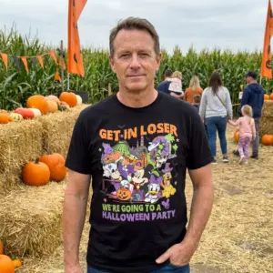 Get In Loser Halloween Party T-Shirt 11 Close-up of a Halloween party scene with festive decorations and playful t-shirts worn by guests.