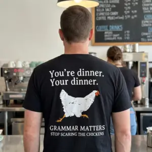 Grammar Matters Chicken Pun T-Shirt 11 Close-up of a black t-shirt displayed casually, featuring a chicken-themed grammar joke.