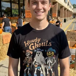 Howdy Ghouls Western Halloween T-Shirt 10 Young adult wearing a Western Halloween T-Shirt in a casual setting.