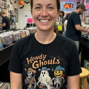 Howdy Ghouls Western Halloween T-Shirt 11 Person dressed in a Western Halloween T-Shirt enjoying a festive environment.