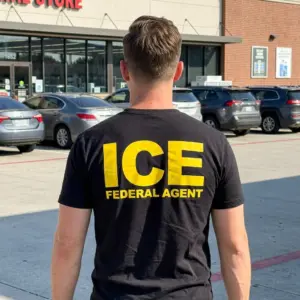 ICE Federal Agent Graphic T-Shirt 11 Person wearing 'ICE Federal Agent' T-shirt in a casual setting.