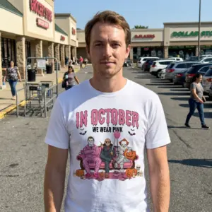 In October We Wear Pink Horror Villains Halloween Shirt 11 Person wearing Halloween shirt with pink-themed villains.
