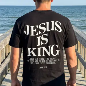 Jesus Is King Christian Verse T-Shirt 11 Model wearing the black 'Jesus Is King' t-shirt in a casual outdoor setting.