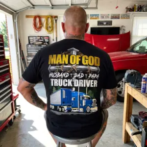 Man of God Christian Truck Driver Dad Papa T-Shirt 11 Close-up of a man in a Christian truck driver t-shirt outdoors.