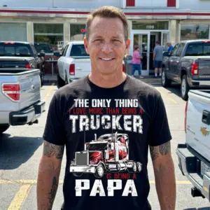 Proud Trucker Papa T-Shirt – Funny Grandpa Gift 10 Black t-shirt featuring the humorous "THE ONLY THING I LOVE MORE THAN BEING A TRUCKER IS BEING A PAPA" design with a red truck, worn as a lifestyle piece.