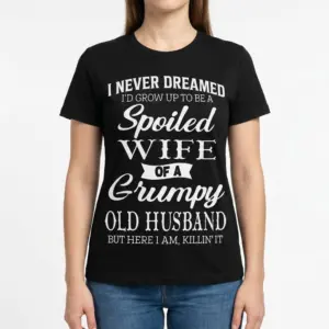 Spoiled Wife of a Grumpy Husband T-Shirt 9 Woman wearing a T-shirt with amusing text about being a spoiled wife.