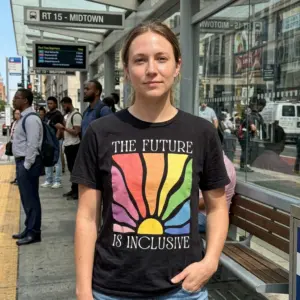 The Future Is Inclusive T-Shirt 11 Person wearing black T-shirt with rainbow design and inclusivity slogan.