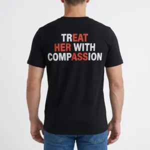 Treat Her With Compassion T-Shirt 9 Male model wearing a humorous designer t-shirt with 'Treat Her With Compassion' on the back.