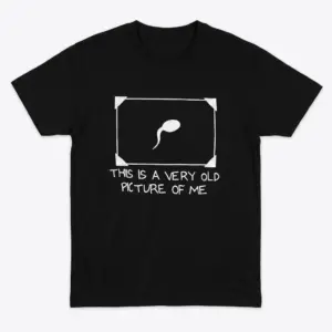 Flat lay of a black t-shirt featuring a framed sperm cell graphic with the text This Is A Very Old Picture Of Me.