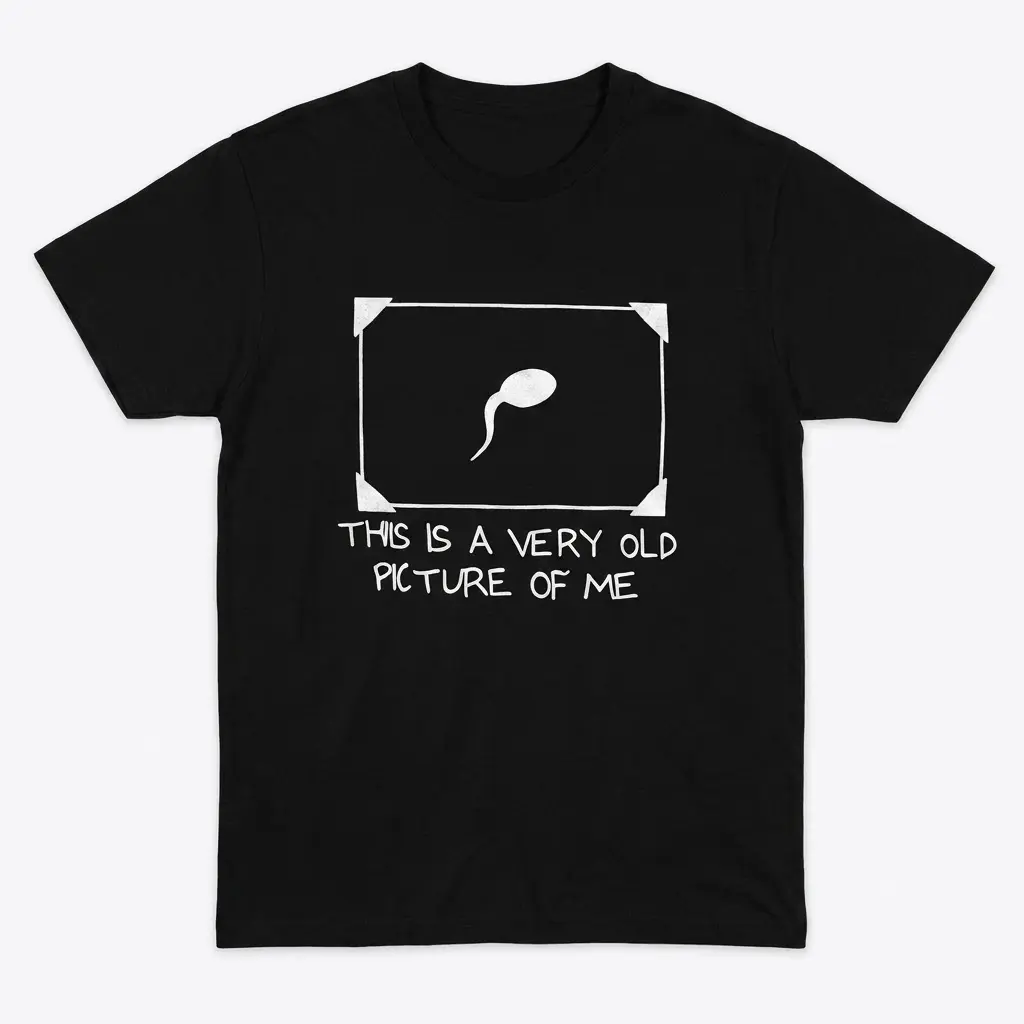 Flat lay of a black t-shirt featuring a framed sperm cell graphic with the text This Is A Very Old Picture Of Me.