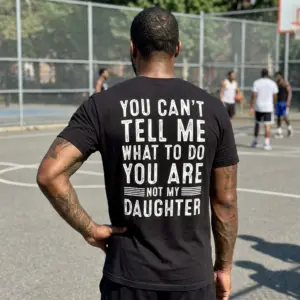 You Can't Tell Me What To Do T-Shirt 11 Casual lifestyle shot highlighting the back of a black shirt with the blunt family joke slogan.