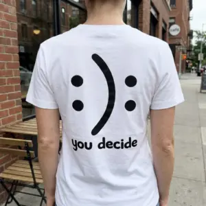 You Decide Happy Sad Optical Illusion T-Shirt 11 A person wearing the white t-shirt with the 'you decide' happy-sad optical illusion graphic on the back in a casual setting.