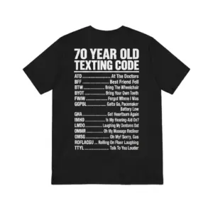 Back view of a black t-shirt featuring the funny 70 Year Old Texting Code humor list in white bold text.