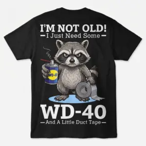 Flat lay back view of a black t-shirt featuring a grumpy raccoon holding WD-40 and duct tape with humorous text.
