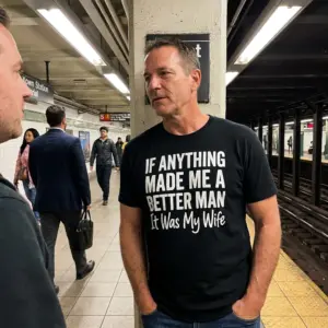 Better Man Because Of My Wife Husband T-Shirt 11 Close-up lifestyle view of the black Better Man Because Of My Wife printed t-shirt worn casually
