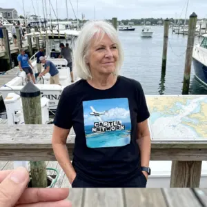 Cartel Network Tropical Island Plane Parody Black T-Shirt 11 Close-up casual look showcasing black tee and black tee front print reading CARTEL NETWORK above a white twin-engine plane over tropical turquoise water