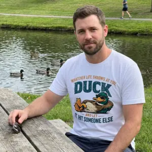 Duck and Let It Hit Someone Else Sarcastic T-Shirt 10 Lifestyle presentation of the sarcastic duck and let it hit someone else shirt in a casual everyday setting.