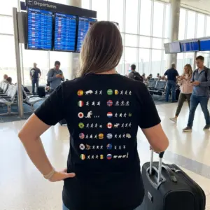 Funny Country Flags Running Stick Figure Meme T-Shirt 11 Close-up casual look showcasing black tee and black tee back print with fourteen circular country flags and stick figures running toward or from funny icons