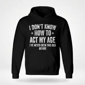 Funny I Don't Know How to Act My Age T-Shirt 7 Front flatlay of a black hoodie with white text that reads 'I Don't Know How to Act My Age I've Never Been This Old Before'.