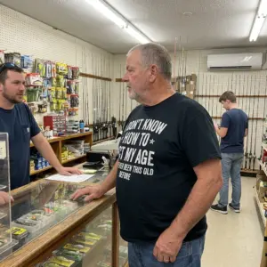 Funny I Don't Know How to Act My Age T-Shirt 10 Older man at a tackle shop counter wearing a black I Don't Know How To Act My Age I've Never Been This Old Before funny birthday shirt