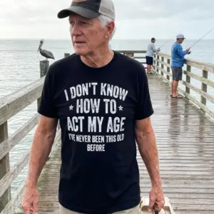 Funny I Don't Know How to Act My Age T-Shirt 11 Close-up lifestyle view of the black shirt featuring the quote 'I've Never Been This Old Before'.