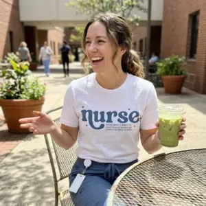 Funny Nurse Rocking It T-Shirt 11 White nurse shirt with a bold blue chest design reading “Some days I rock it. Some days it rocks me.”