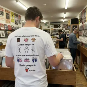 I Don't Care Who You Are I Hate Everyone Sarcastic T-Shirt 10 Everyday streetwear outfit styling white shirt with back print reading I don't care what colour your skin is what size you are I hate everyone with stick
