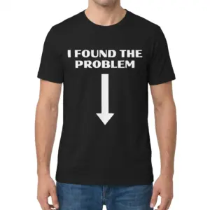 I Found The Problem Downward Arrow Funny Sarcastic T-Shirt 9 Man wearing black graphic tee with black tee front print reading I FOUND THE PROBLEM above a large bold white arrow pointing straight down