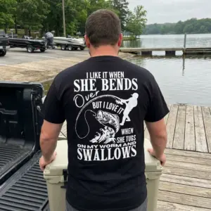 I Like It When She Bends Over Funny Fishing Innuendo T-Shirt 11 Close-up casual look showcasing black tee and black tee back print reading I LIKE IT WHEN SHE BENDS OVER with an angler silhouette and jumping bass fish