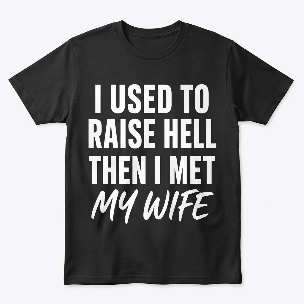 Flatlay of a black t-shirt reading "I Used to Raise Hell Then I Met My Wife" in bold white text.
