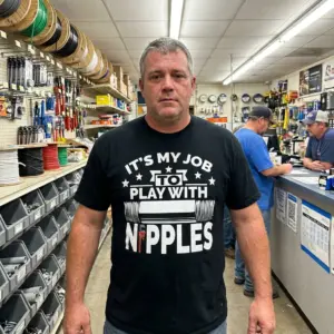 Its My Job to Play With Nipples Funny Plumber T-Shirt 10 Lifestyle view of the funny It's My Job to Play With Nipples plumber shirt in an everyday setting.