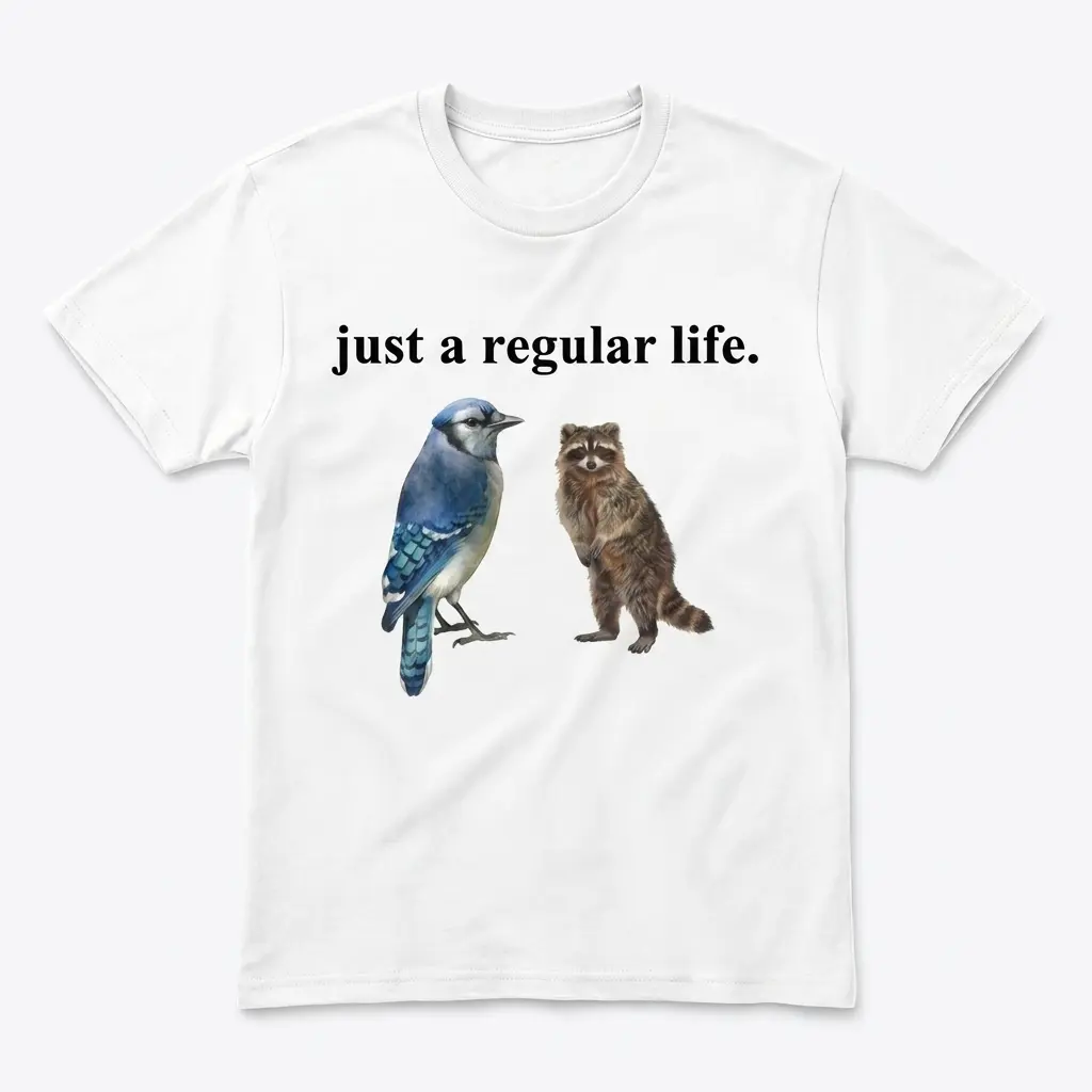 Just A Regular Life Blue Jay And Raccoon Funny White T-Shirt 1 Flatlay white t-shirt featuring white tee front print reading JUST A REGULAR LIFE above a realistic watercolor blue jay and standing brown raccoon