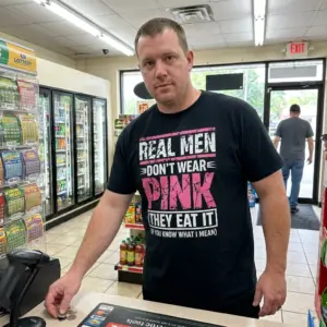 Real Men Don't Wear Pink They Eat It Funny T-Shirt 10 Everyday lifestyle shot featuring a person wearing the real men dont wear pink shirt with its bold white and pink text.