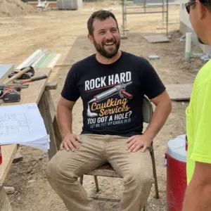 Rock Hard Caulking Services Funny T-Shirt 11 Alternate lifestyle view showcasing the funny caulking graphic shirt.