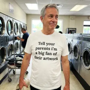 Tell Your Parents I'm A Big Fan Of Their Artwork T-Shirt 11 Close-up casual look showcasing white tee and white tee front print reading Tell your parents im a big fan of their artwork in bold black serif text