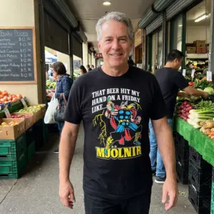 That Beer Hit My Hand On A Friday Like Mjolnir Funny T-Shirt 11 Close-up casual look showcasing black tee and black tee front print reading THAT BEER HIT MY HAND ON A FRIDAY LIKE MJOLNIR with a comic thunder warrior