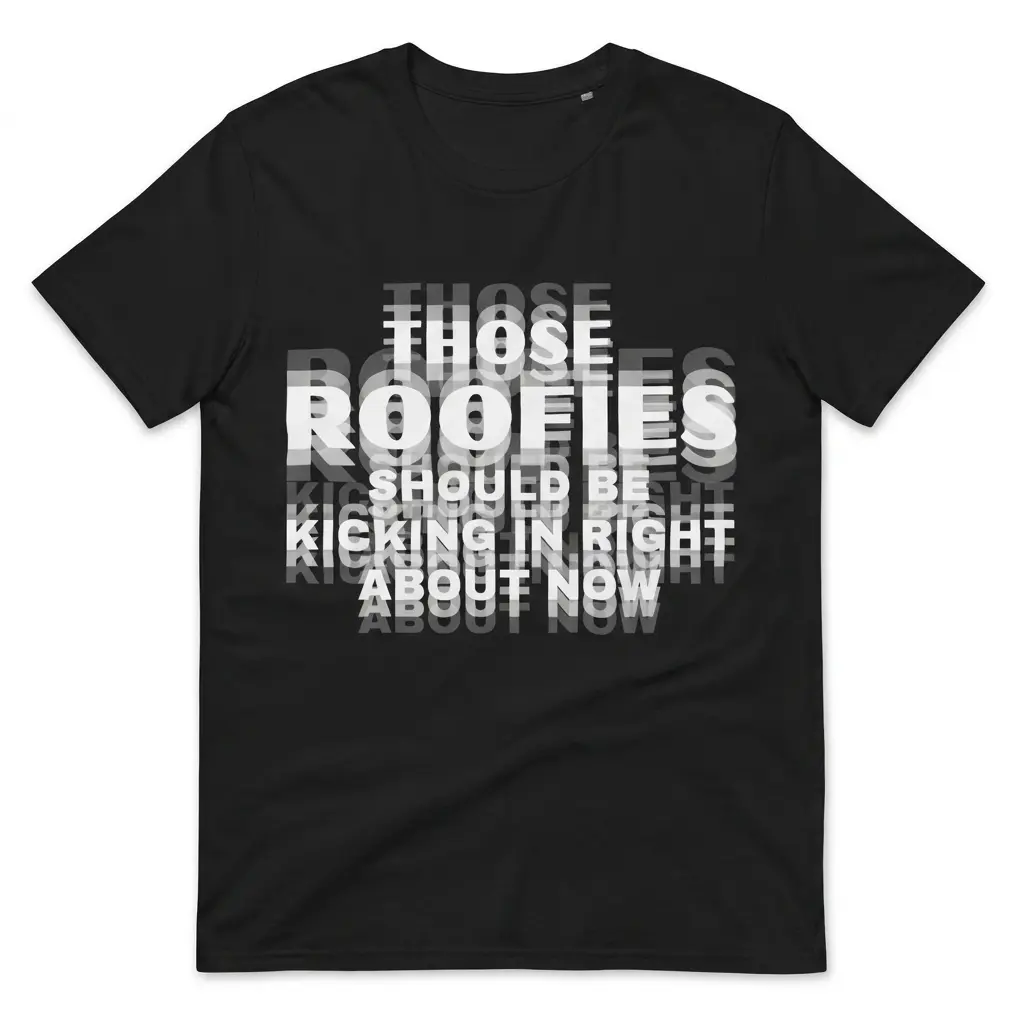 Flatlay black t-shirt featuring black tee front print reading THOSE ROOFIES SHOULD BE KICKING IN RIGHT ABOUT NOW in blurry layered text