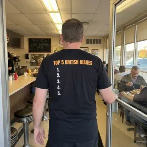 Top 5 British Dishes Blank List Funny Roast T-Shirt 10 Everyday streetwear outfit styling black shirt with black tee back print reading TOP 5 BRITISH DISHES in orange above a blank numbered list 1 to 5
