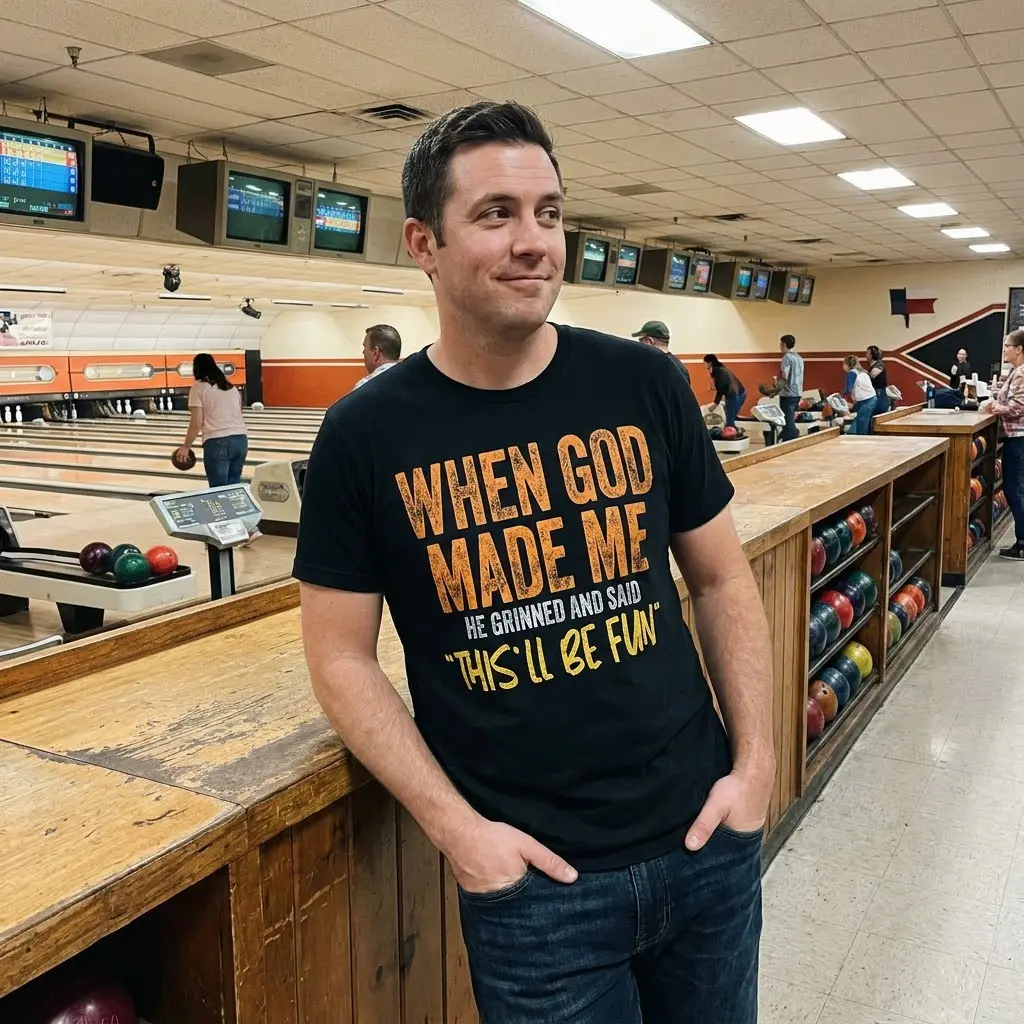 Close-up lifestyle shot of the humorous graphic t-shirt reading "When God Made Me He Grinned And Said 'This'll Be Fun'".