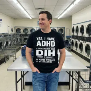 Yes I Have ADHD A Dangerously Huge Dih Funny Acronym T-Shirt 10 Everyday streetwear outfit styling black shirt with black tee front print reading YES I HAVE ADHD A DANGEROUSLY HUGE DIH DEFICIT IN HUMANITY in white text