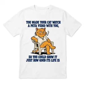 Flatlay white t-shirt featuring white tee front print reading YOU MADE YOUR CAT WATCH A PETA VIDEO WITH YOU above a cartoon orange cat