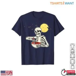 Navy blue t-shirt featuring a funny Halloween skeleton eating a bowl of ramen noodles with chopsticks under a yellow full moon